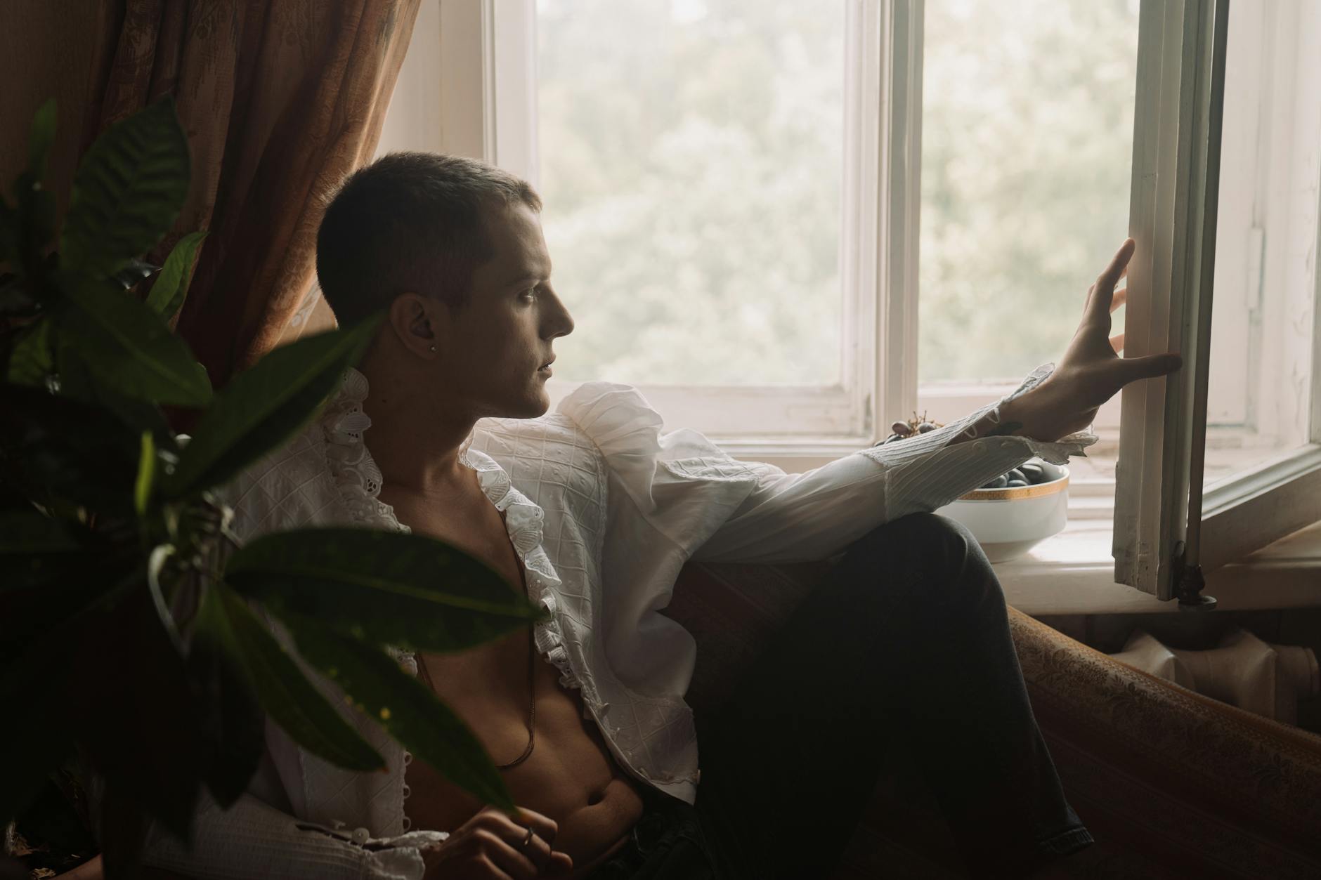 man in white dress shirt sitting on bed