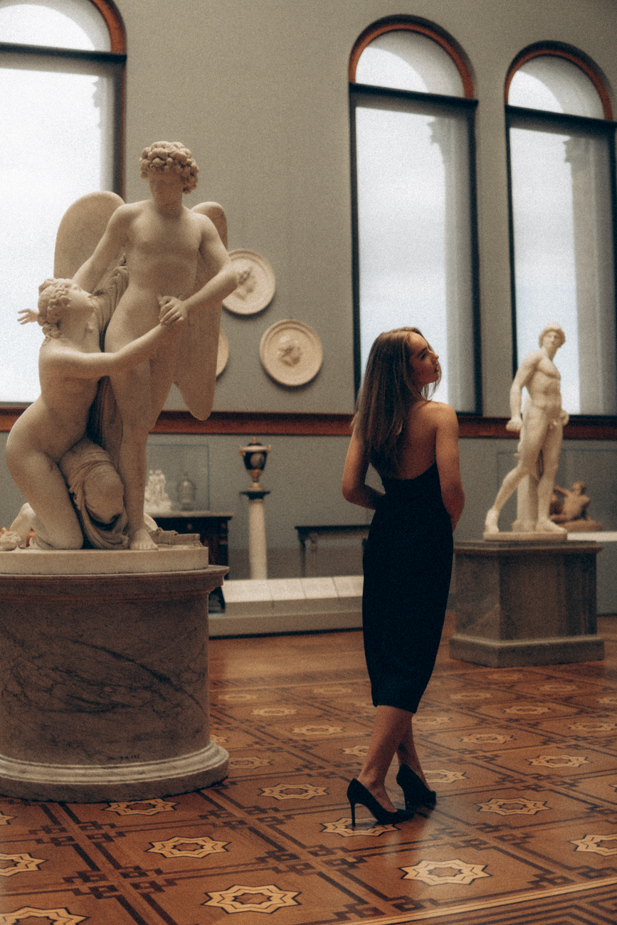 a woman wearing a backless dress in a museum