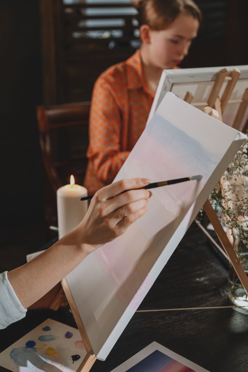 close up of woman painting on canvas on group class